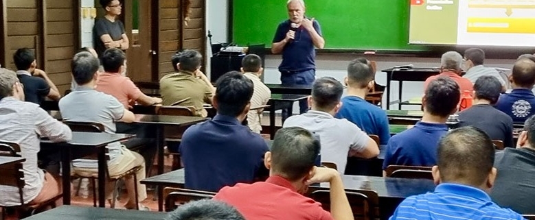 jóvenes varones en aula escuchando exposición